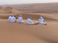 Poušť  Wahiba sands.  Naši řidiči čekají, až se nabažíme západu slunce v dunách. Se svými turbany na hlavě si umně kryjí i oči a obličej. Teď jasně vidíme praktičnost tohoto oblečení. : Wahiba sands.