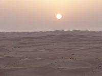 Poušť  Wahiba sands.  Západ slunce nad pouští Wahiba Sands. Škoda, je to trošku v oparu. Jemný písek nám fičí do očí. : Wahiba sands.